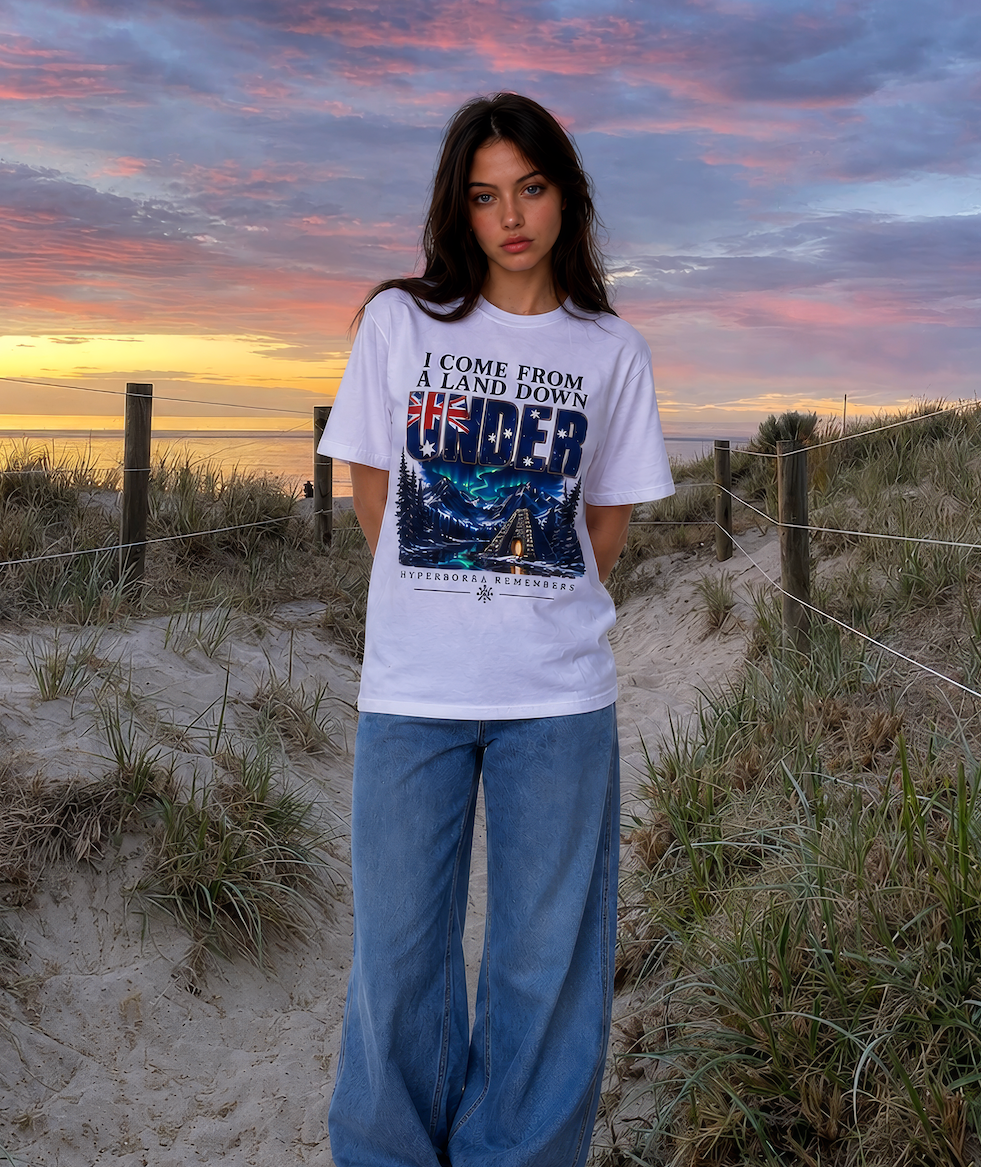 Person wearing a graphic t-shirt on a beach at sunset